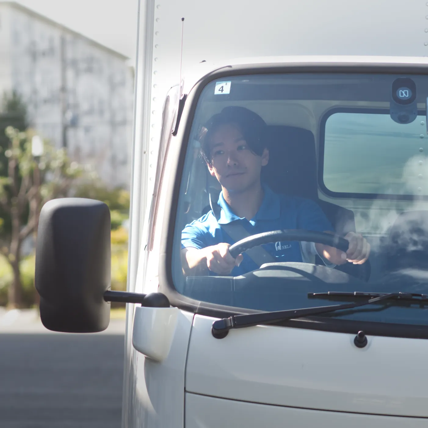 配送車の運転席で働くドライバー｜採用サイトの写真撮影・写真編集